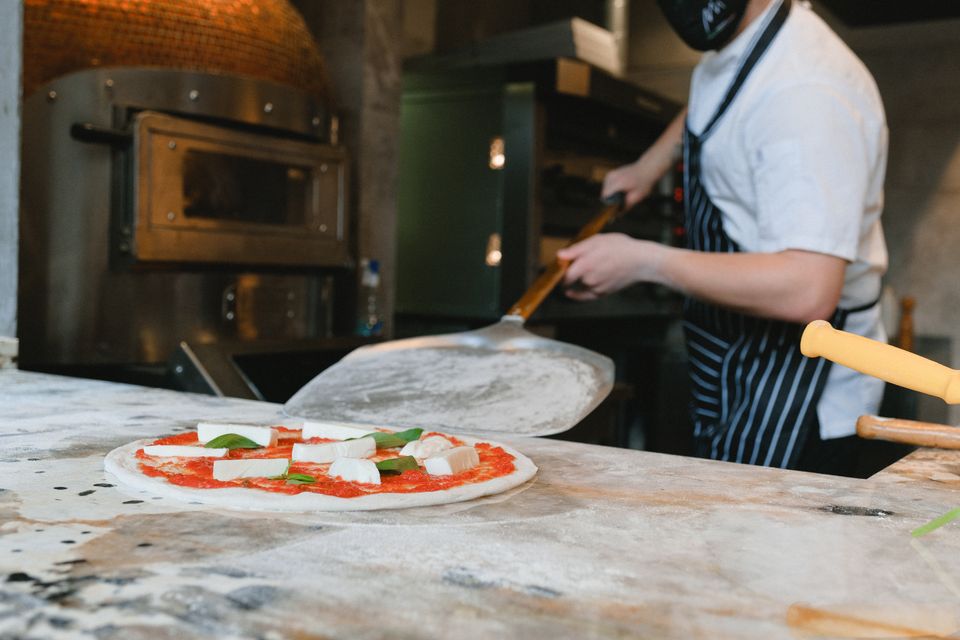 Il pizzaiolo stende l'impasto